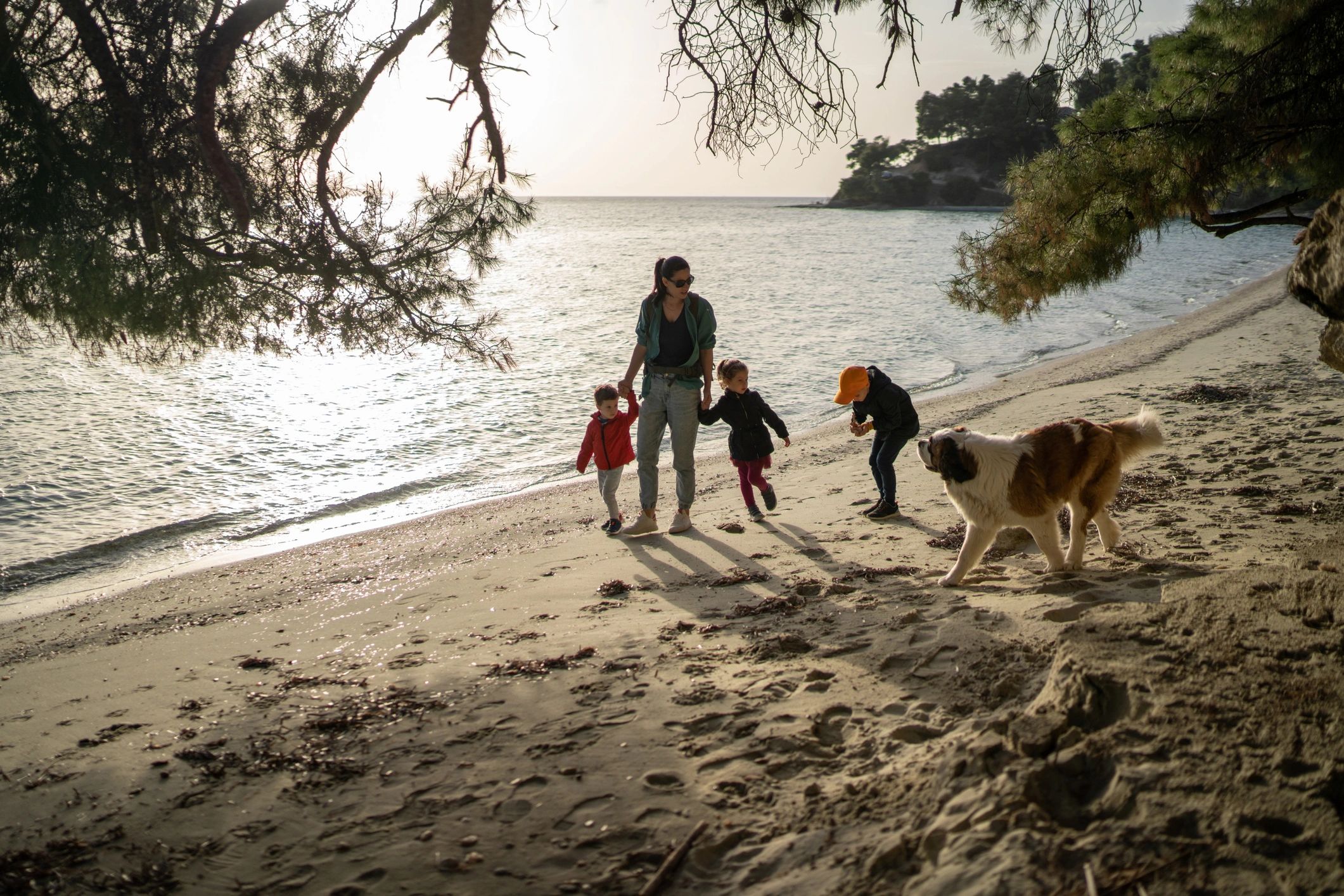 Familia caminando en la playa al atardecer para representar actividades y paseos